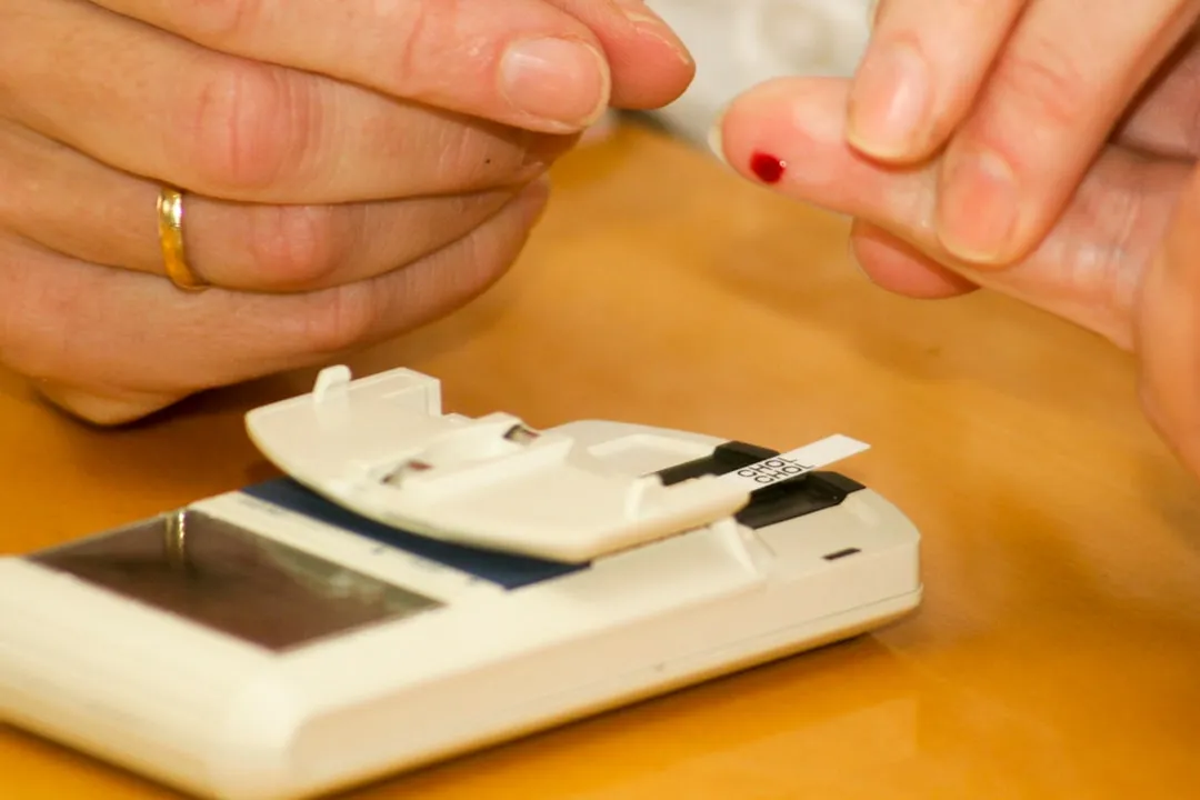 Person putting blood on a glucometer