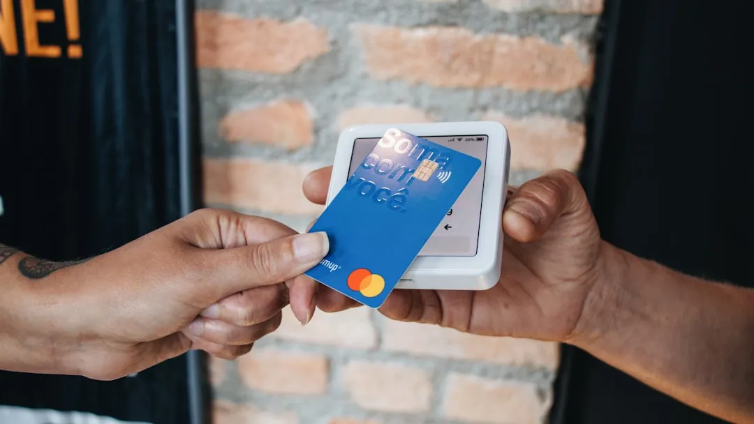 A person handing a credit card to another person