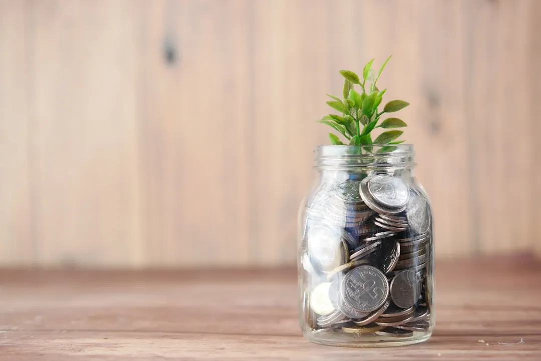 A glass jar full of coins and a plant