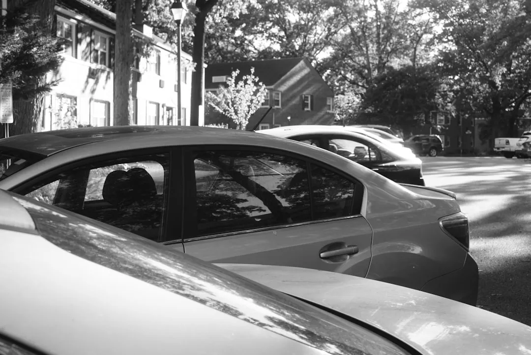 Uma foto em preto e branco de carros estacionados em uma rua