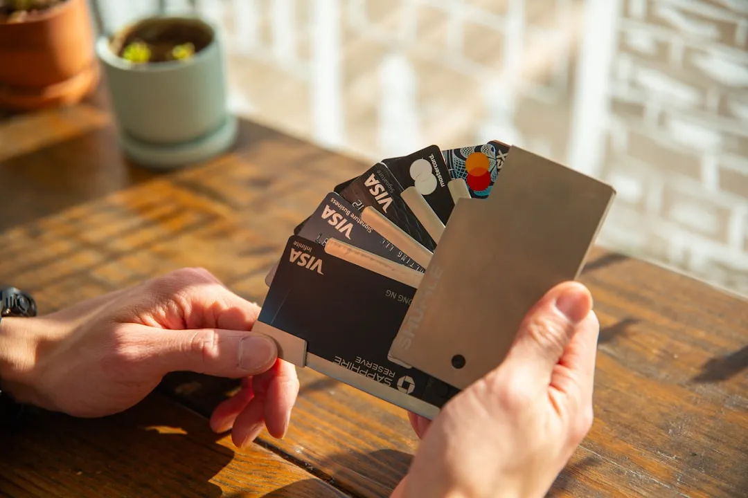 A person holding a credit card in their hand A person holding a credit card in their hand