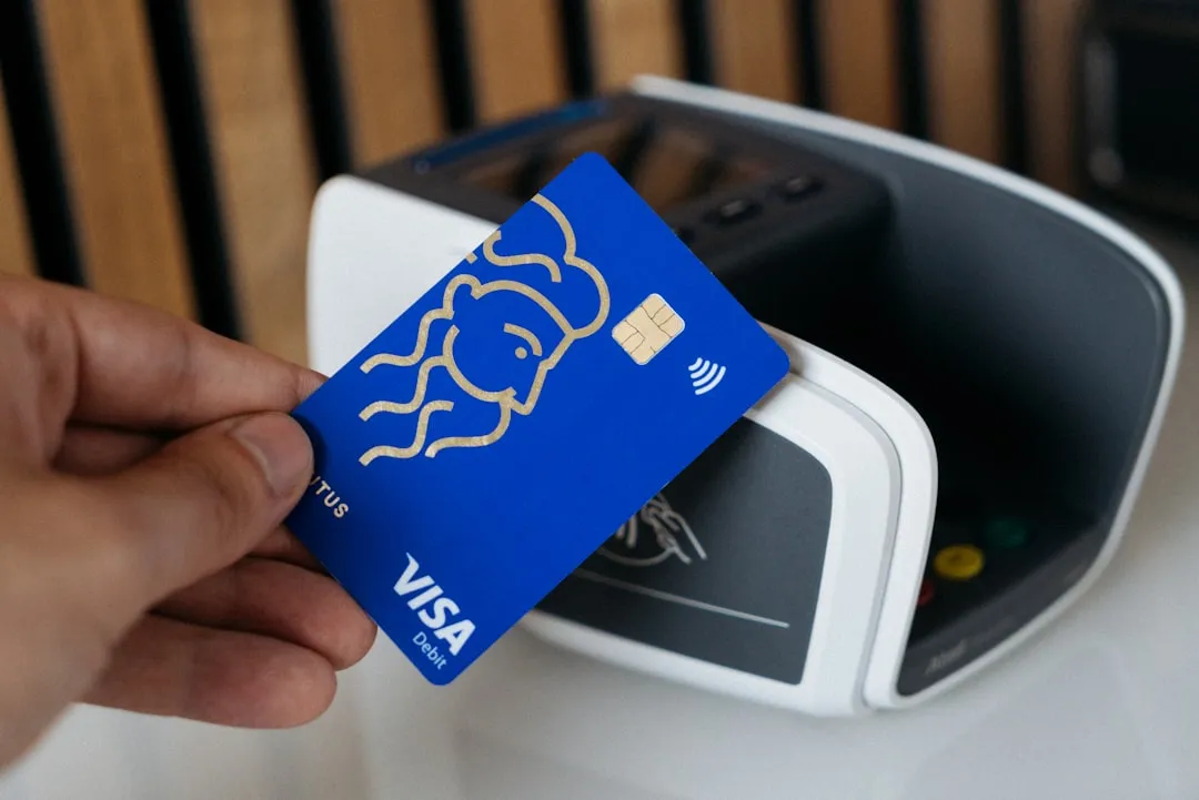 A person is holding a blue credit card A person is holding a blue credit card