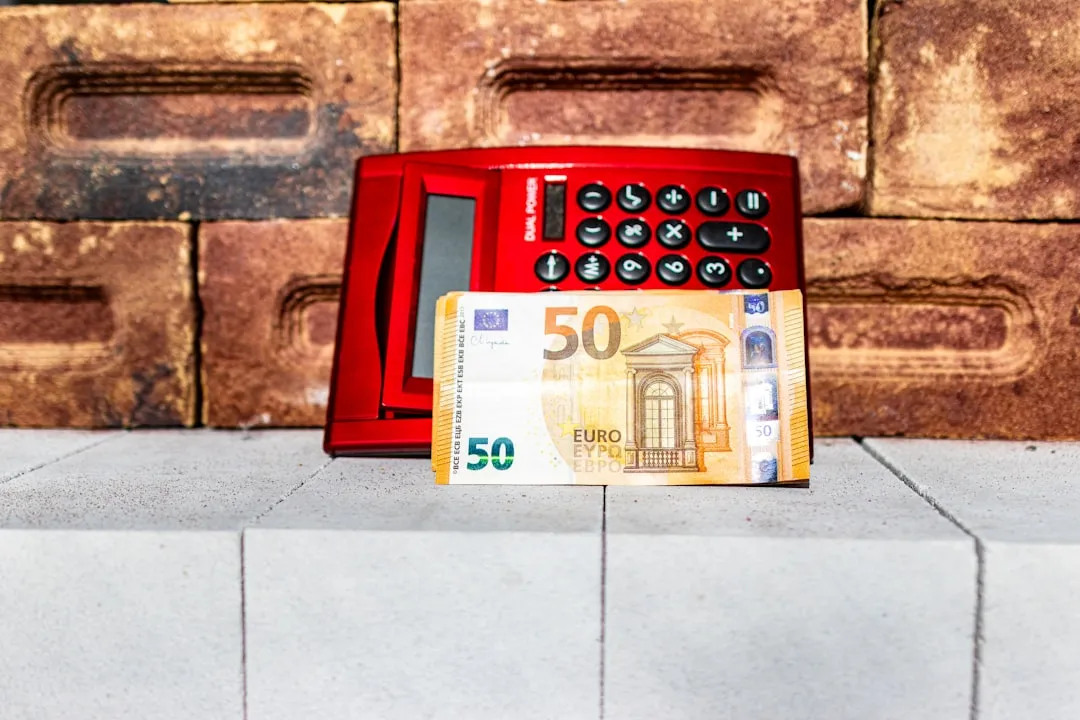 A red telephone on a counter next to a 50 euro bill
