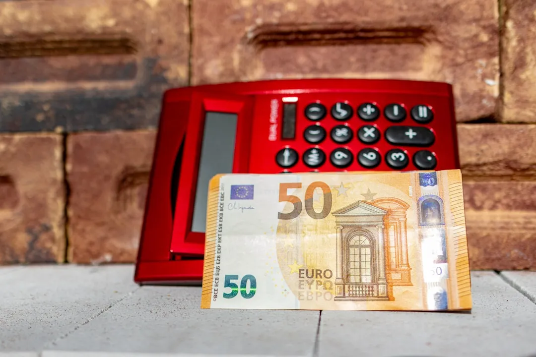 A 50 euro bill next to a red telephone