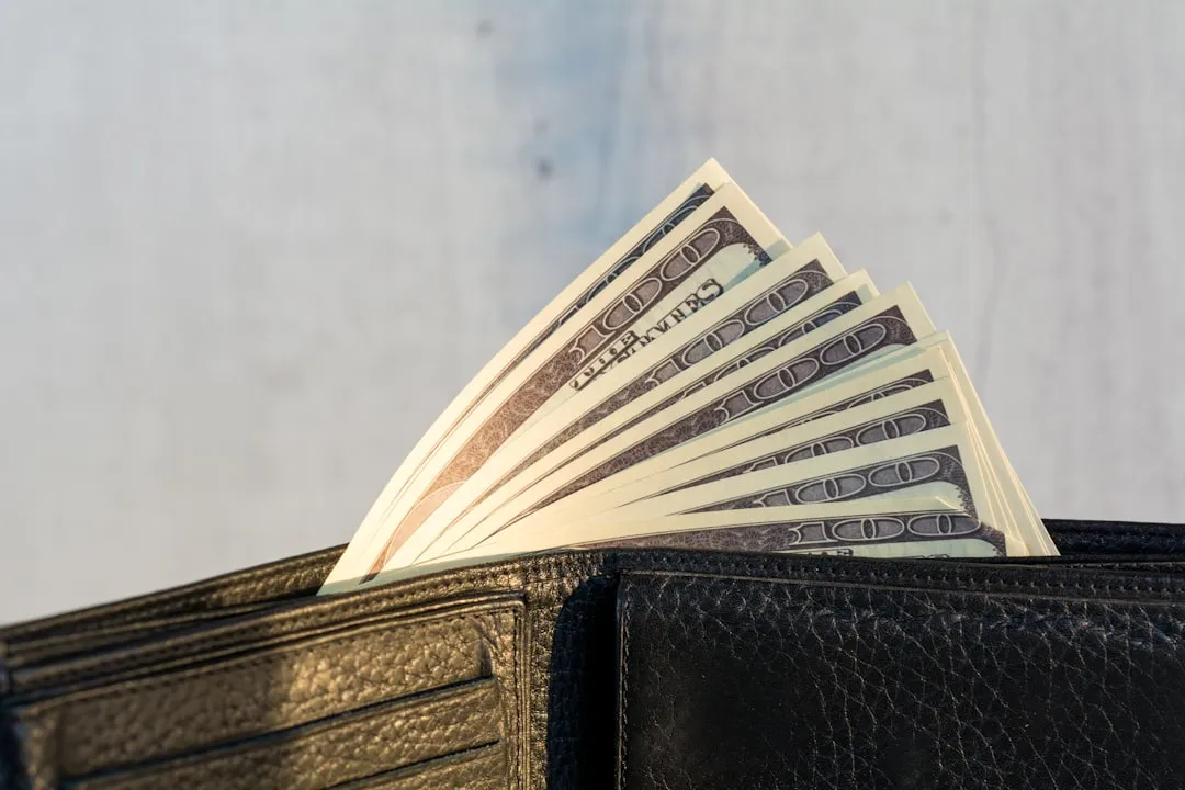 A wallet with a stack of twenty-dollar bills sticking out of it