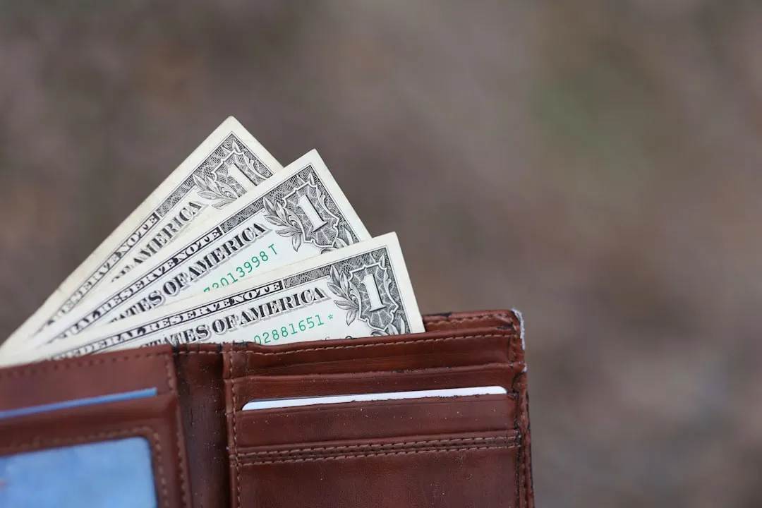 A wallet with five-dollar bills sticking out of it