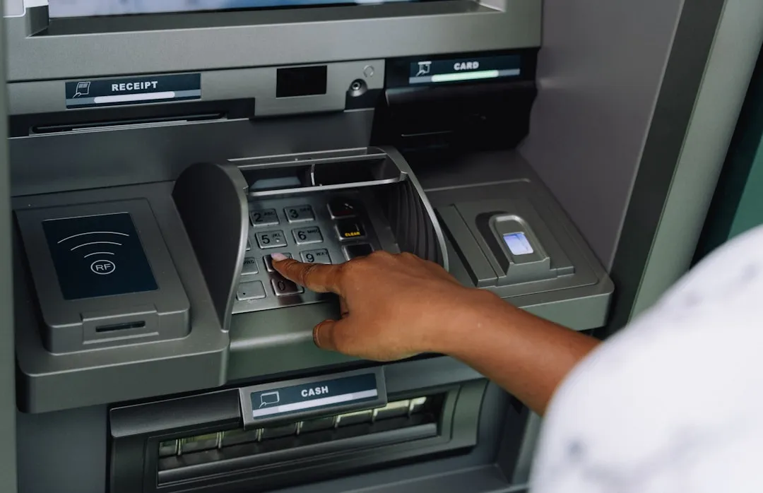 A person using an ATM, one of the few physical touchpoints in the digital banking ecosystem.