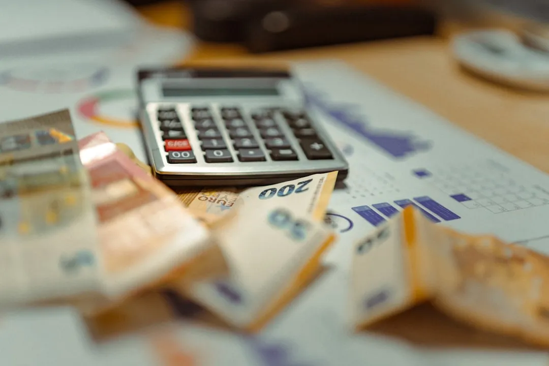 A calculator on top of a pile of money