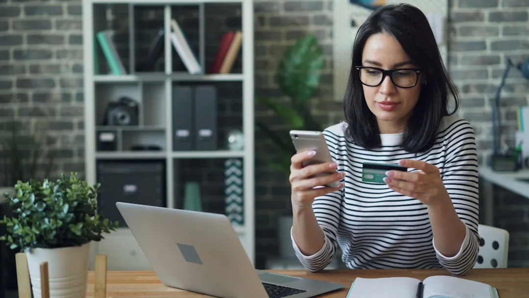 A woman sitting at a table looking at her cell phone