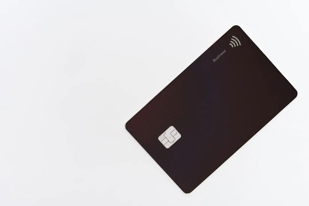 A black business credit card with a chip on a white background